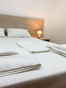 基辅Міні-Готель Білий Квадрат的一张带白色床单和毛巾的床