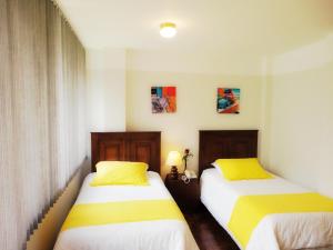 基多斯堪的纳维亚角酒店的两张带黄色枕头的床