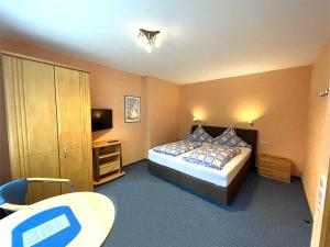 科赫姆苏伟古斯瑟姆酒店的一间卧室配有一张床、一张桌子和一台电视。