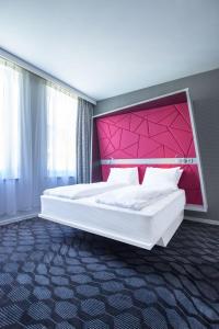 卑尔根艾克斯比申麦吉克酒店的一间卧室配有一张带粉红色床头板的大床