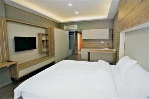 卡特佩Bureau Residence的一间带白色大床的卧室和一间浴室