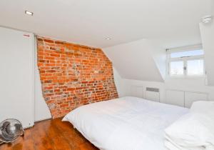沃辛Central Apartment Bedford Loft的一间卧室设有砖墙和一张床
