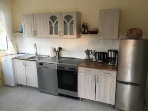 巴拉通马里亚弗都Villa Ida的厨房配有白色橱柜和不锈钢冰箱