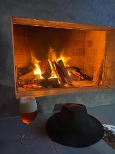 兰舒凯马杜Cabana Guimarães的壁炉旁的帽子和一杯啤酒