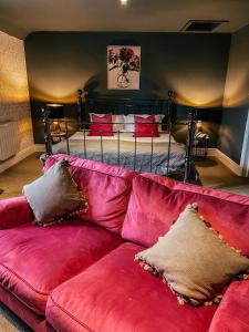 埃文河畔斯特拉特福The Stratford Park Hotel & Golf Club的客厅里一张红色的沙发,配有一张床