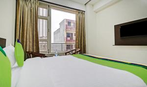 MohaliTreebo Kamron Regency Sector 80的一间卧室设有一张大床和一个大窗户