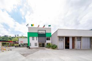 马尼萨莱斯Ayenda Panamericana的白色绿色的建筑,设有停车场