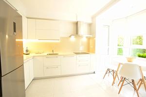 圣塞瓦斯蒂安Go Donosti Villa Berio的厨房配有白色橱柜和桌椅