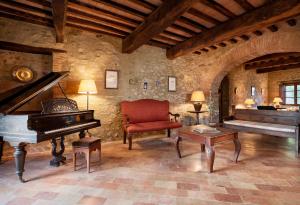 Monte CastelliBorgo Il Poeta的客厅配有钢琴和椅子