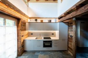 博萨迪法萨Chalet Catinaccio Rosengarten 56的厨房配有白色橱柜和炉灶。