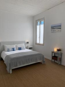 加斯泰L'Estanquet Bed and Breakfast pdj offert的白色的卧室设有一张大床和一个窗户