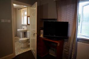 伯明翰Adnans Hotel的浴室设有带电视的梳妆台和卫生间。