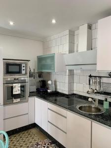 蓬费拉达Alojamiento estilo Boho con mucho encanto的厨房配有白色橱柜和水槽