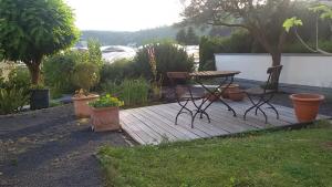 科布伦茨Domizil Koblenz的木甲板,配有野餐桌和一些植物