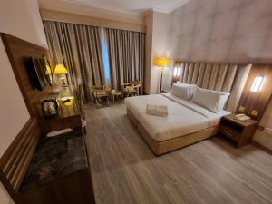 迪拜Vista Square Hotel的酒店客房设有一张大床和一张桌子。