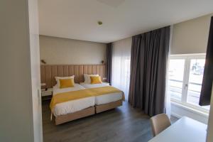 科英布拉Hotel Mondego的酒店客房配有一张带黄色枕头的床