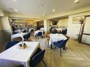 图尔恰城市酒店的餐厅设有白色的桌子和蓝色的椅子
