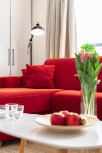 奥斯坦德Las Dunas - 30m van het strand的客厅配有红色的沙发和带水果的桌子