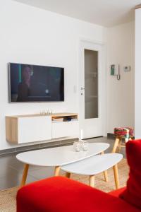 奥斯坦德Las Dunas - 30m van het strand的客厅配有红色沙发和电视
