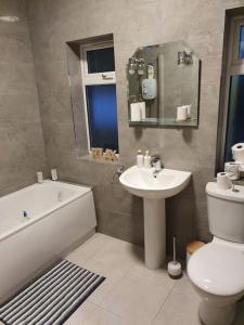 基利贝格斯Private 3 bedroom house ideal for family & friends的浴室配有盥洗盆、卫生间和浴缸。