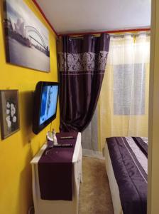 圣巴托洛梅boungalow Mena Playmar的一间卧室配有一张床和一张桌子上的电视