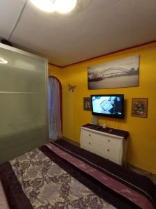 圣巴托洛梅boungalow Mena Playmar的一间卧室配有一张床,并在橱柜上配有电视