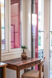 纳夫普利翁Silo Luxury Rooms的窗户房间里一张桌子上放着植物