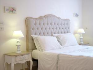 奥斯图尼Masseria Cappuccini的卧室配有一张白色大床和两盏灯。
