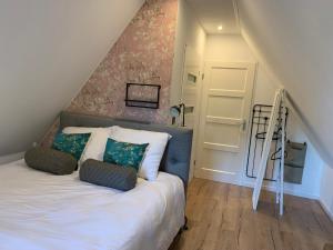 新阿姆斯特丹B&B bij Vincent的一间卧室配有带2个枕头的床和楼梯