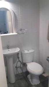 梅塞德斯Apartamento-Loft的白色的浴室设有卫生间和水槽。