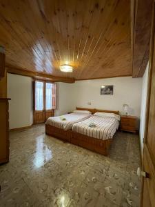 巴加Can Xuneta的一间卧室设有一张带木制天花板的大床