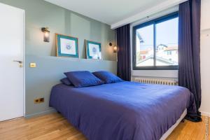 比亚里茨VILLA BIBI CHERI Elégante Suite de 35 M2的一间卧室设有蓝色的床和窗户。