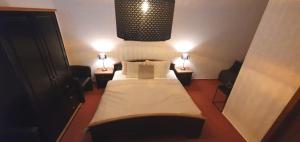 RochlitzStadthotel的一间带一张床和两盏灯的小卧室