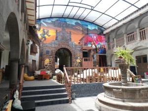 库斯科Pariwana Hostel Cusco的一座带楼梯的建筑,墙上挂着壁画
