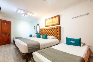 巴耶杜帕尔Ayenda Orquidea 19的两张位于酒店客房的床,配有蓝色枕头