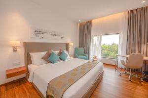 尼甘布Vivanta Colombo, Airport Garden的一间设有大床和窗户的酒店客房