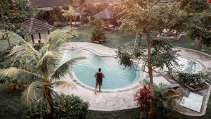 乌鲁瓦图Village Bali的站在游泳池旁的人