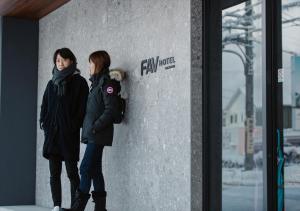 高山FAV HOTEL HIDATAKAYAMA West的两个女人站在墙上