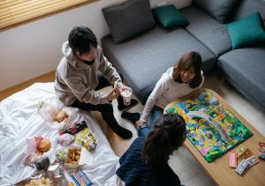 高山FAV HOTEL HIDATAKAYAMA West的一群坐在客厅里吃食物的孩子