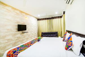 海得拉巴FabHotel Pride Inn的一间酒店客房,配有一张床和一台电视