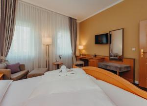 汉堡文托夫爵格克劳斯酒店的配有一张大床和镜子的酒店客房
