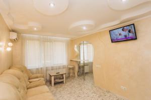 苏梅VIP Харьковская的客厅配有沙发和墙上的电视