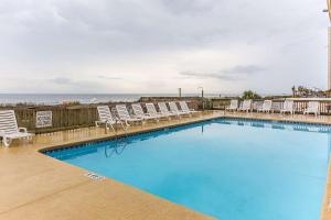 默特尔比奇Ocean Star Hotel的一个带椅子的大型游泳池,并享有海景