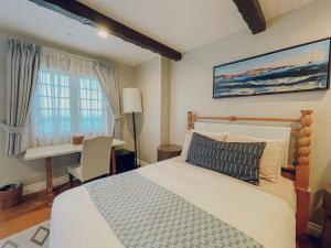 阿瓦隆Zane Grey Pueblo Hotel的一间卧室配有一张床、一张书桌和一个窗户。