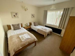诺里奇Cherry Tree Lodge的一间卧室设有两张床和窗户。
