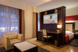 波恩ACHAT Sternhotel Bonn的酒店客房设有一张床、一张书桌和一台电视机。