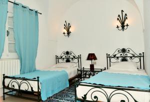 哈马马特BUNGALOW El HOUDA的卧室设有两张蓝色和白色的床