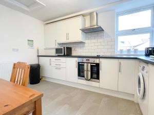 克鲁Spacious 2-bed Apartment in Crewe by 53 Degrees Property, ideal for Business & Professionals, FREE Parking - Sleeps 3的厨房配有白色橱柜和炉灶烤箱。