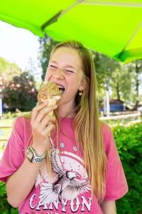 哈尔德伦TopParken - Resort Veluwe的一位年轻女孩用雨伞吃甜甜圈