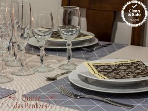 蓬塔德尔加达Quinta das Perdizes的一张桌子上放有盘子和酒杯